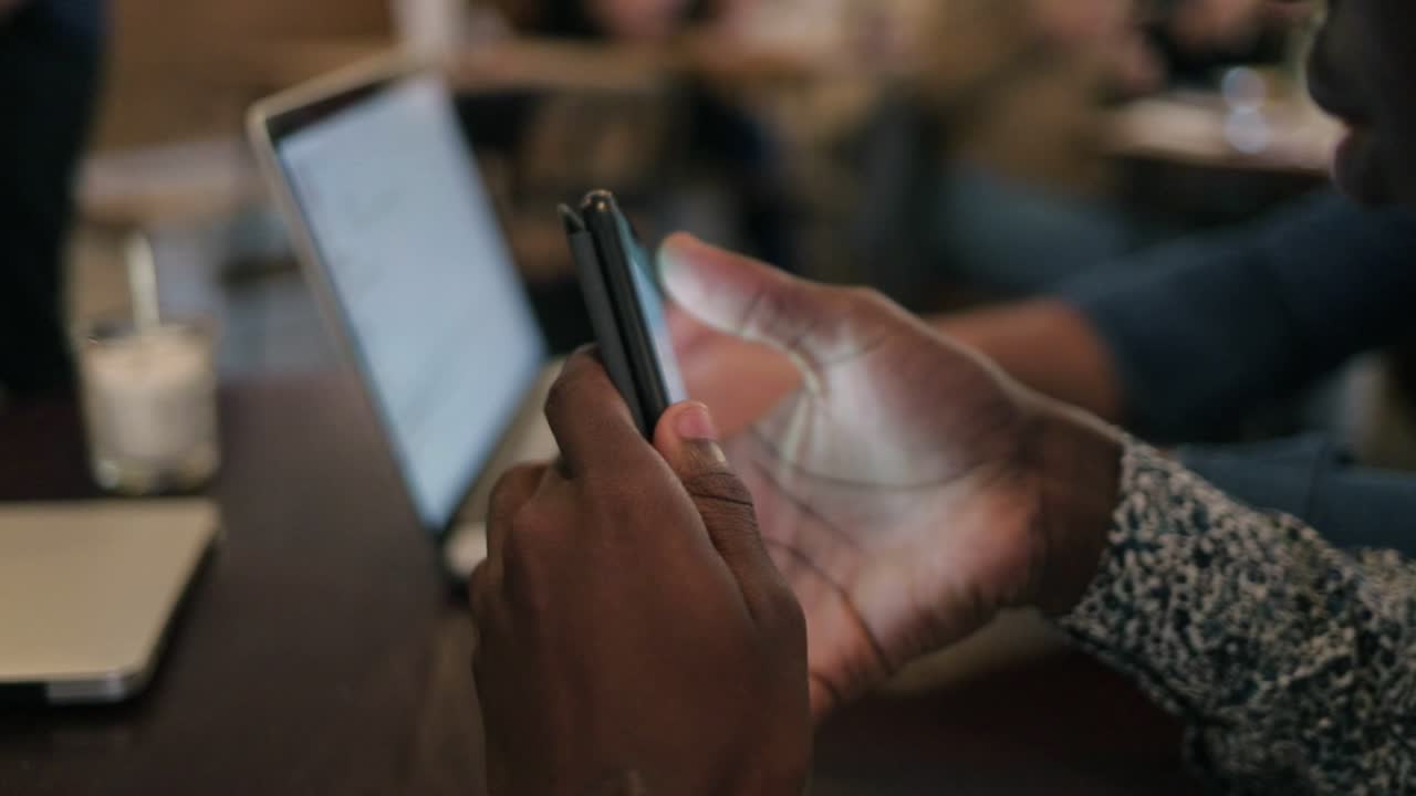 African American man using smartphone in cafe