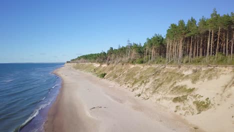 Luftaufnahme-Des-Ostseestrandes-In-Jurkalne-An-Einem-Sonnigen-Tag,-Weiße-Sandklippe-Beschädigt-Durch-Wellen,-Küstenerosion,-Klimaveränderungen,-Aufsteigender-Weitwinkel-drohnenschuss,-Der-Sich-Vorwärts-Bewegt-1