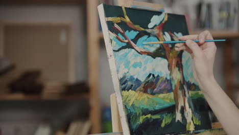 close-up of an artist painting a landscape