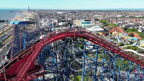 Drohnenflug-Aus-Der-Luft-über-Den-Blackpool-Pleasure-Beach,-Der-Langsam-Schwenkt,-Um-Einen-Atemberaubenden-Blick-Auf-Die-Küste-Und-Den-Blackpool-Tower-In-Der-Ferne-Zu-Offenbaren