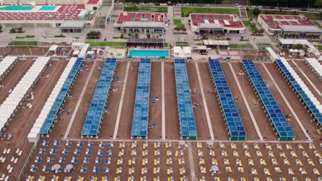 aerial view of a bustling beach resort with rows of tents and sun loungers