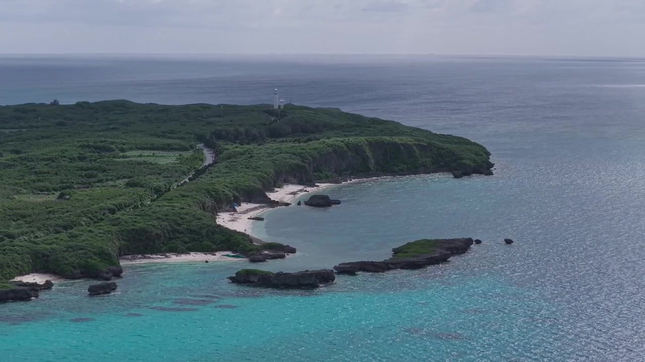 Riprese aeree orizzontali che si spostano a sinistra e inquadrano a destra lungo la costa frastagliata di Kaginmi Beach, isola di Ikema, Okinawa, Giappone.