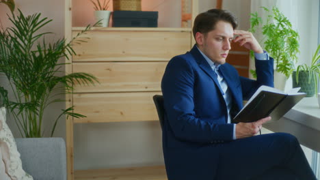 Businessman-Analyzes-Notes-at-Desk