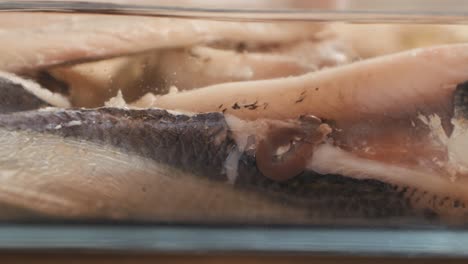 fresh sea sardines and anchovy fish and mullus on display on ice on market store shop. seafood fish background, close up stand of small salty white fish.