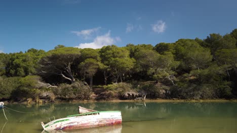 Incline-Hacia-Abajo-Para-Revelar-Un-Bote-De-Remos-Hundido-Abandonado-En-Aguas-Del-Estuario,-España