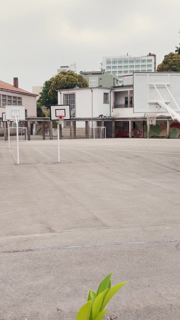 Pátio de escola fechado para o verão ou durante greve ou quarentena, com quadra de basquete sem alunos. POV de câmera de celular em pátio vazio em um reel de mídia social estilo UGC de vlogger.