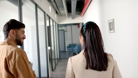 walking through office hallway, colleagues discussing work and heading to meeting
