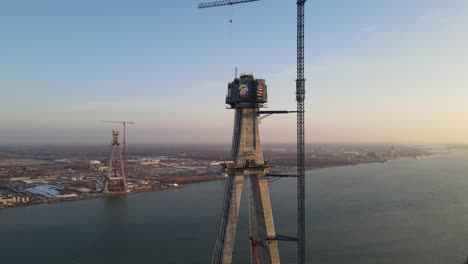 engineers building bridge over vast river to connect usa and canada, aerial drone view