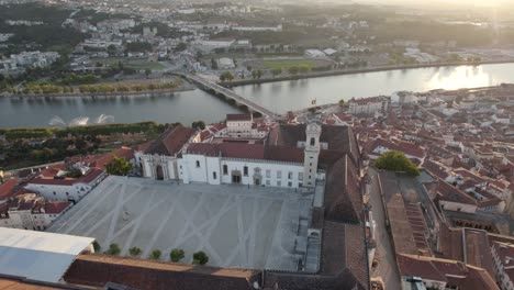 aerial top down view orbit over coimbra university of law, mondego river backgound