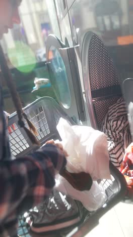 mujer lavando la ropa en una lavandería