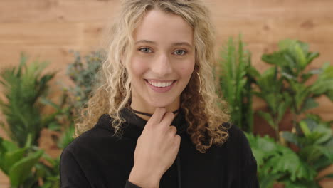 portrait of attractive young blonde woman smiling cute looking at camera playful wearing hoodie