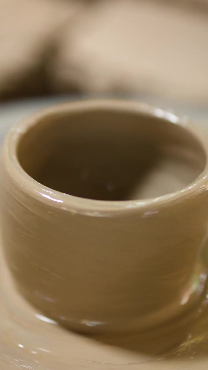 Artisan hands mold wet clay into a ceramic pot on a spinning wheel in Nonthaburi.