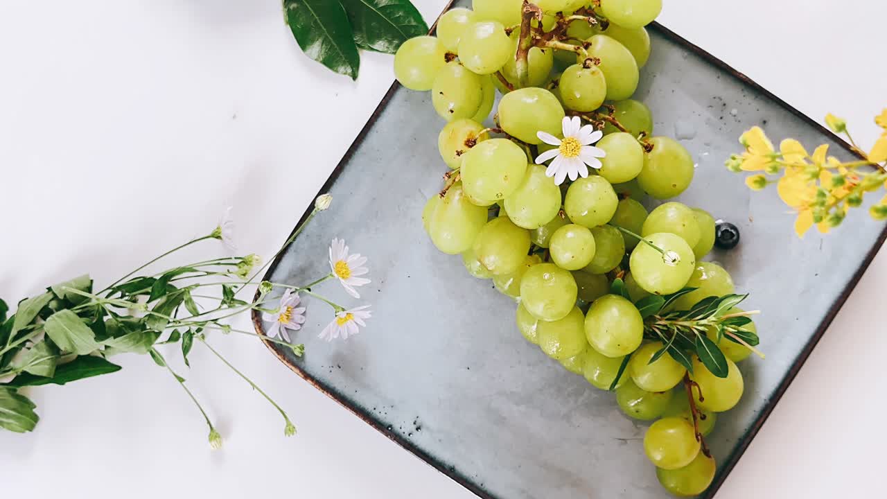 uvas verdes con flores en un plato