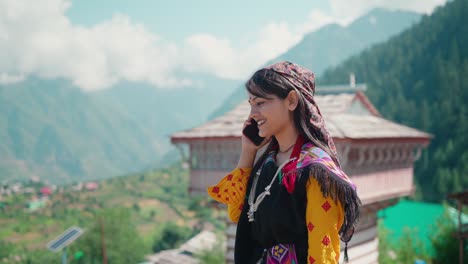 young indian rural woman in traditional attire talking on smartphone in village.