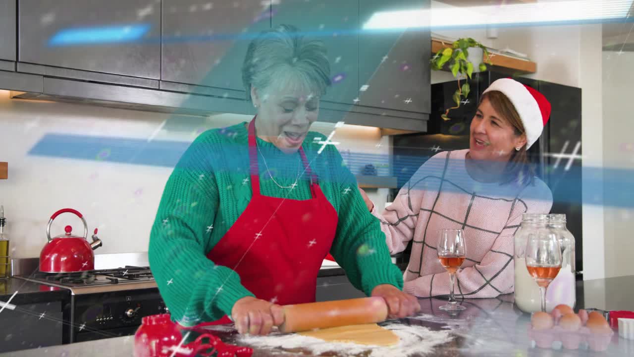 Senior woman pressing and rolling dough in holiday kitchen, daughter watching sparkles over hands