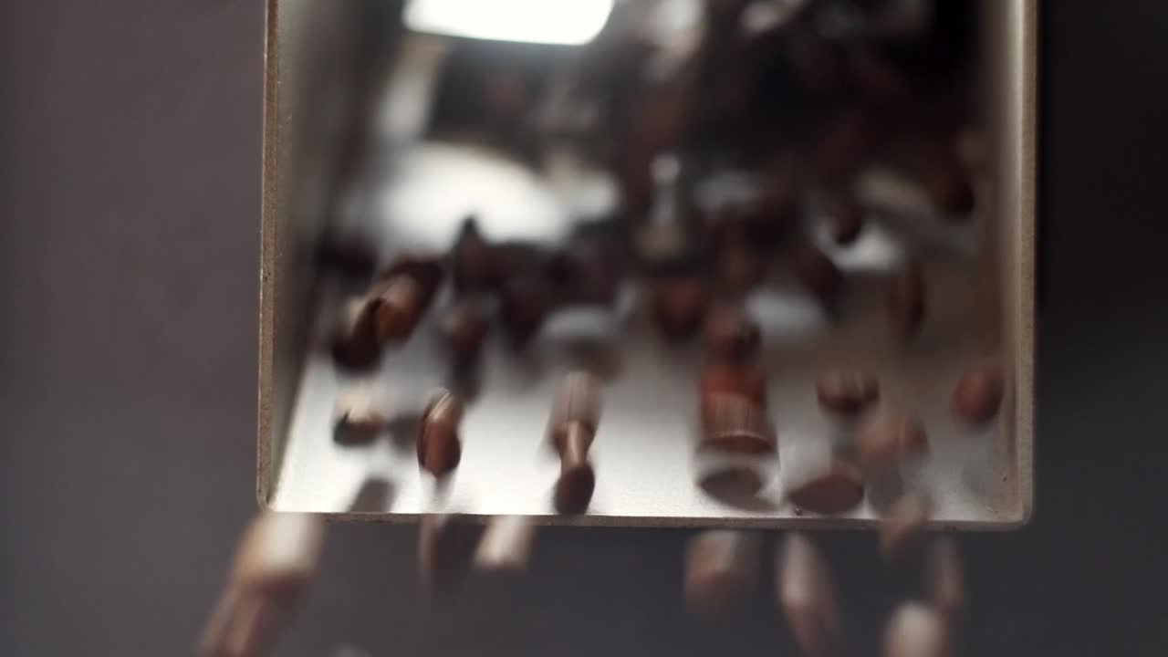 Close up view of Toasted coffee beans coming out of a coffee toaster.