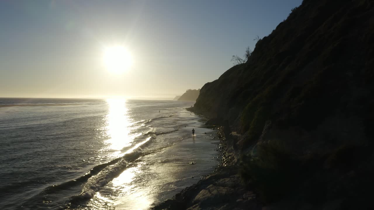 황금시간대에 해변에서 달리는 남자의 조감도