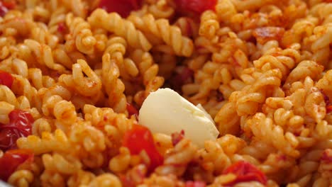 Ein-Esslöffelgroßes-Stück-Ungesalzene-Butter-In-Einer-Pfanne-Mit-Fusilli-Nudeln-Und-Tomatensauce-Schmelzen-Und-Verkleinern