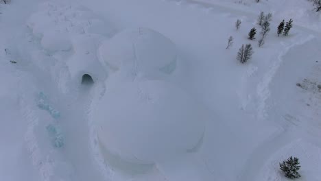 Drohnenansicht-Der-Tromsø-Berge-Im-Winter-Voller-Schnee,-Die-Ein-Igluförmiges-Eishotel-Von-Oben-In-Norwegen-Zeigt