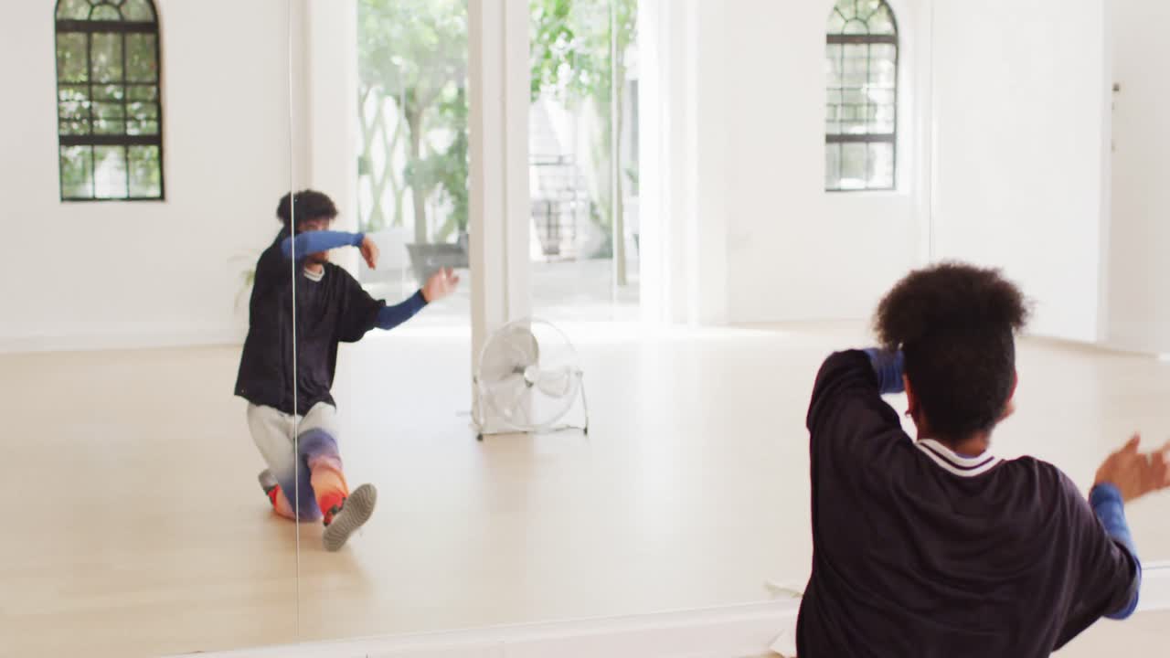 댄스 스튜디오에서 거울 앞에서 혼자 춤을 추는 두 인종의 남성 댄서, 슬로우 모션