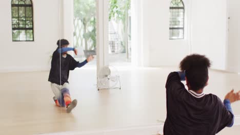 Biracial-male-dancer-dancing-alone-in-front-of-mirror-in-dance-studio,-slow-motion