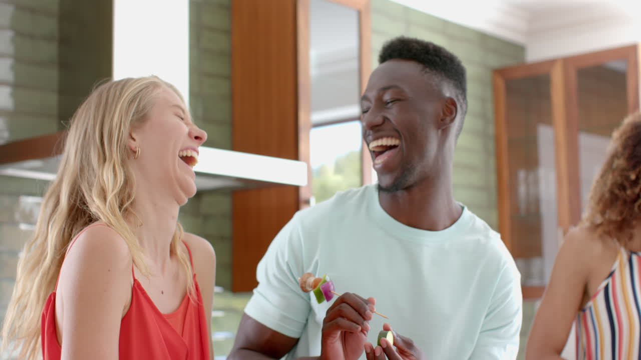 Young African American man shares a joyful moment with a young Caucasian woman at home
