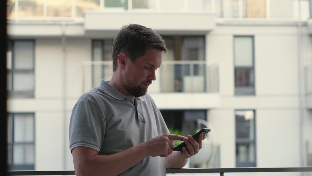 hombre usando un teléfono inteligente en un balcón
