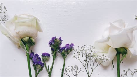 rosas blancas delicadas y flores púrpuras
