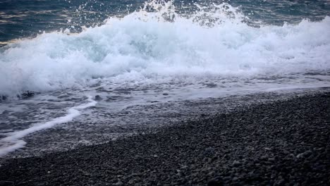 Meereswellen-über-Einem-Kiesstrand-Aus-Kieselsteinen-Mit-Einer-Perspektive-Aus-Niedrigem-Winkel-In-Zeitlupe