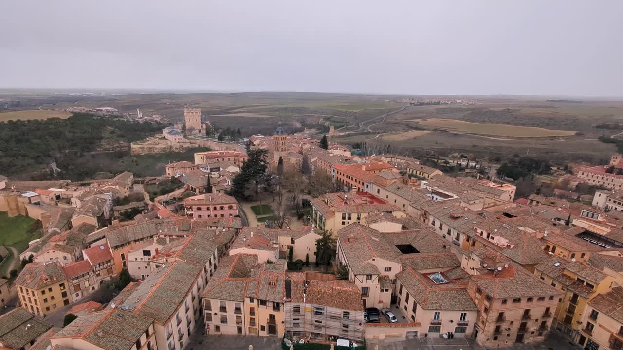 incline hacia arriba la vista aérea del alcázar de segovia y la ciudad durante la mañana nublada de invierno con copos de nieve cayendo