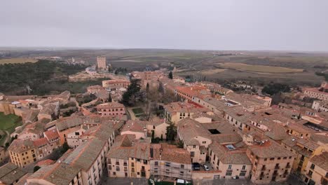 tilt up aerial view of segovia alcazar and city during winter cloudy morning with snow flakes falling