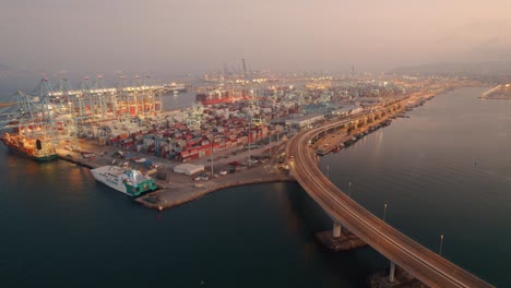 aerial view of algeciras port, close to the container terminal with some vessel alongside and the bridge that connects the port to the city