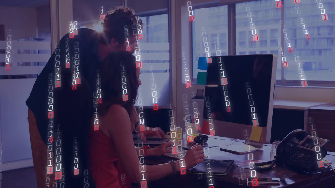 woman tapping tablet displaying floating data while coworker pointing monitor and working in tech