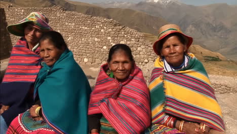indigenous women in traditional attire at a mountainous cultural site
