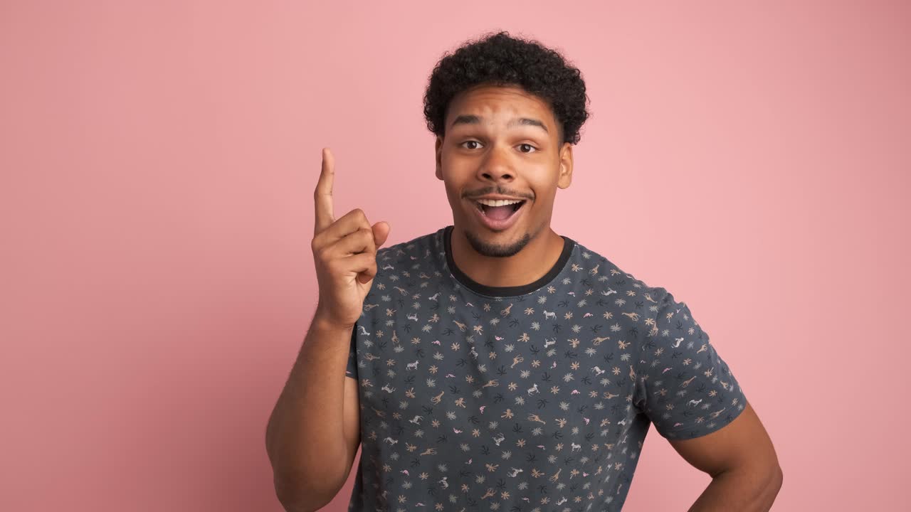 Thoughtful young man with great idea in pink studio