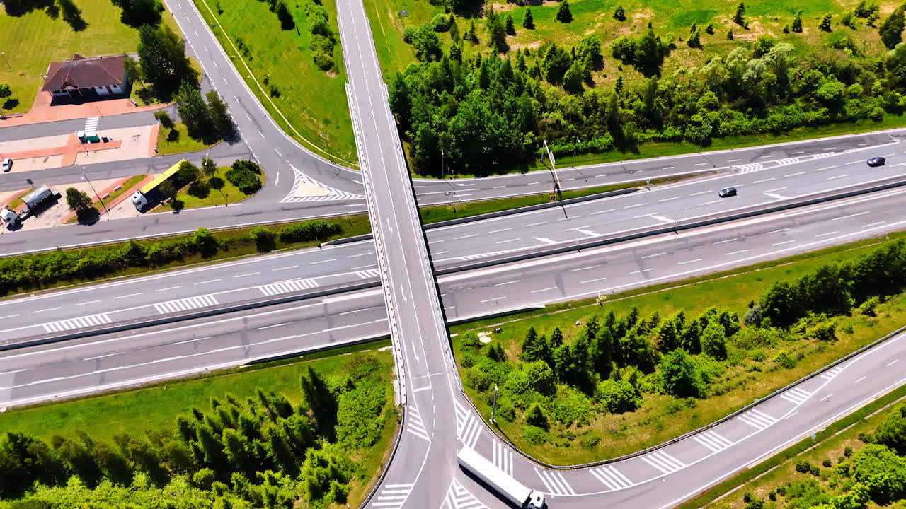 Freeway over the roads in the countryside. Cars and lorries move by the highways. Top view.