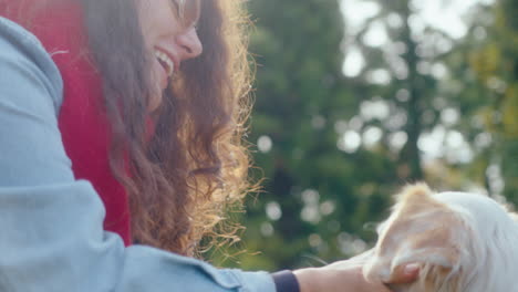 happy woman giving treats to dog in the park