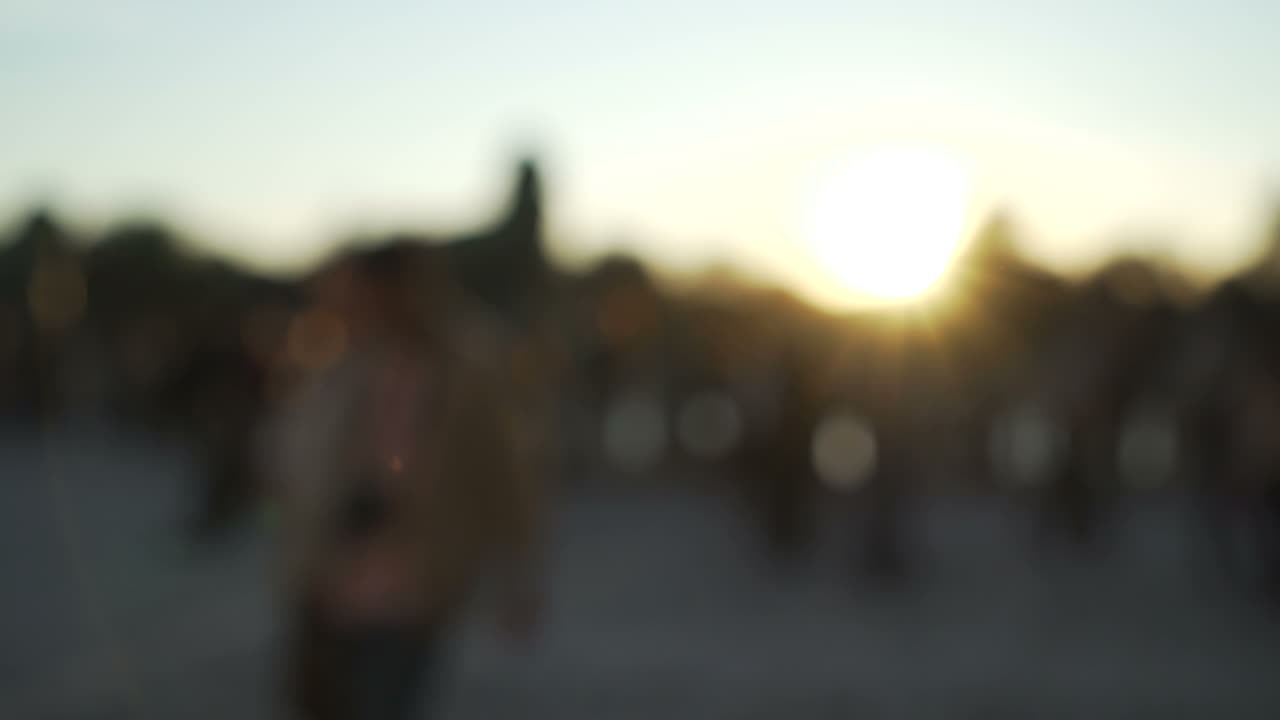 Beautiful out of focus sunset. People walking at the park