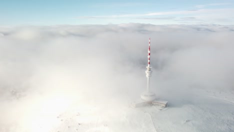 torre de transmisión y vigilancia cubierta de nubes y niebla en el pico de la montaña prad en la república checa. - fotografía aérea