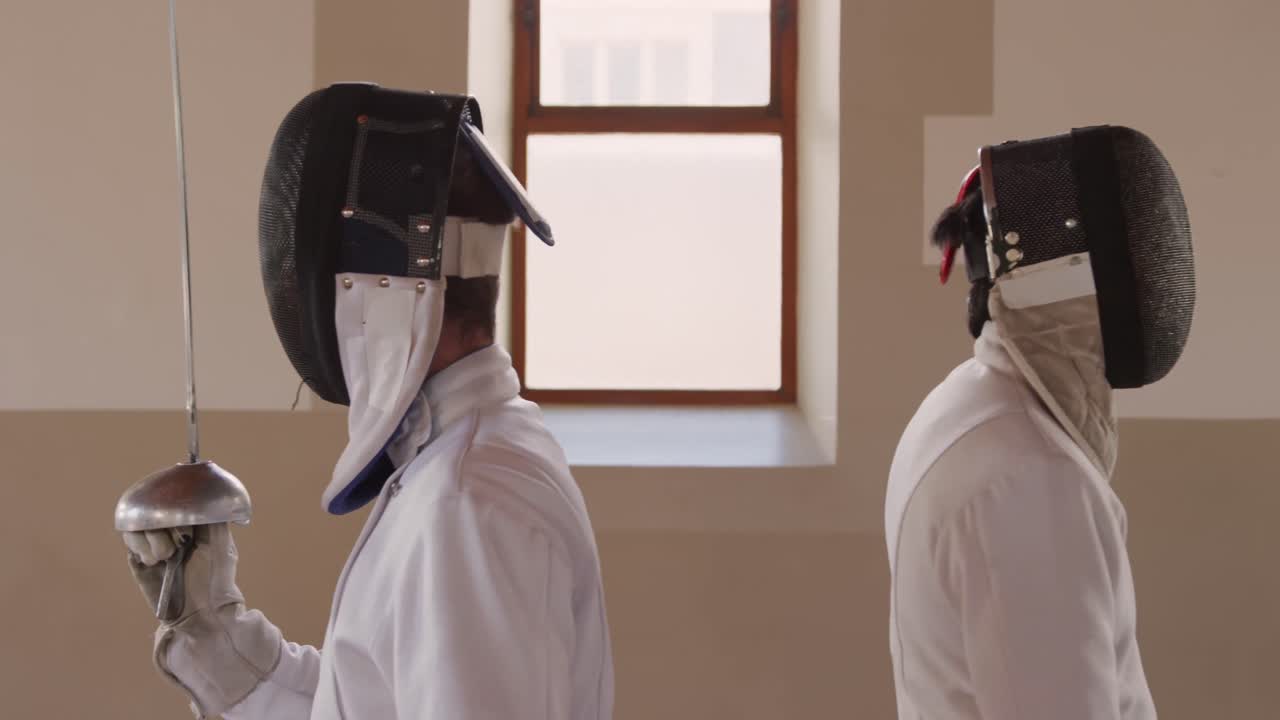 atletas de esgrima durante un entrenamiento de esgrima en un gimnasio