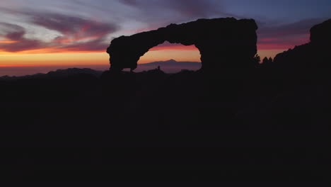 Aerial-view-traveling-out-the-Nublo-window-during-the-sunset,-with-beautiful-colors