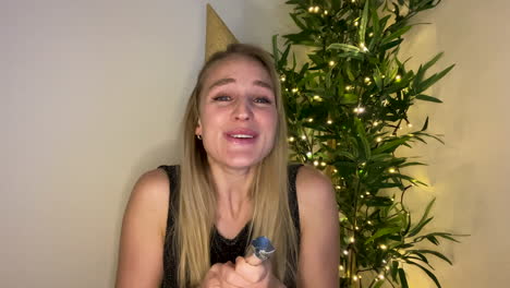 young woman on video call countdown to new year and celebrating with party popper