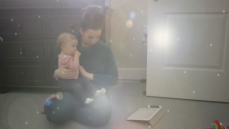 Glowing-spots-of-lights-against-woman-holding-a-baby