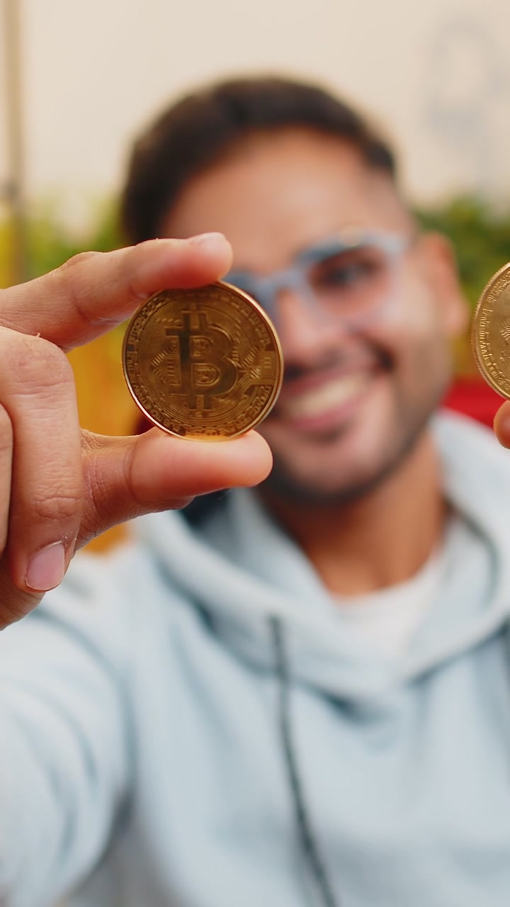 Homem indiano comerciante de ações ganhando bitcoins monitoramento on-line operações de negociação mineração segurar moedas btc