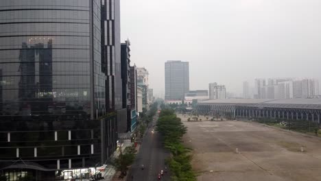 Drone-dolly-above-empty-street-passing-black-reflecting-modern-building-in-vietnam