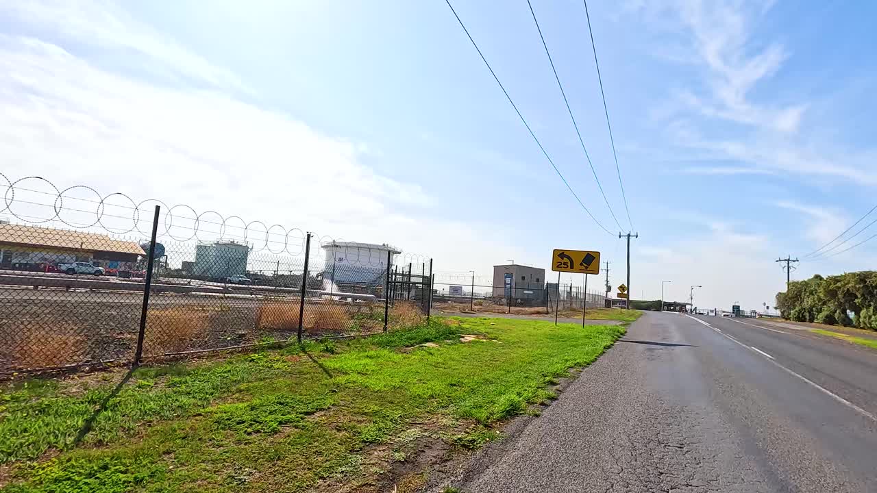 A 9-second video captures a sunny roadside view in Geelong, showcasing industrial buildings and lush greenery under a clear sky