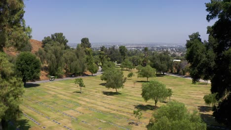 wide rising aerial shot of a burial lawn with rows of headstones at a mortuary in california