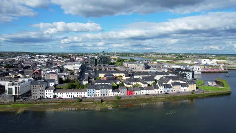 sideway drone shot of colorful houses on the long walk of galway bay