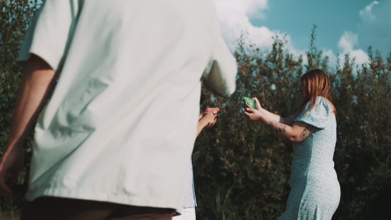 Friends Playing with Water Guns Outdoors