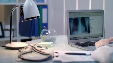 Doctor-working-with-xray-on-laptop-at-workplace.-Radiologist-check-x-ray-picture